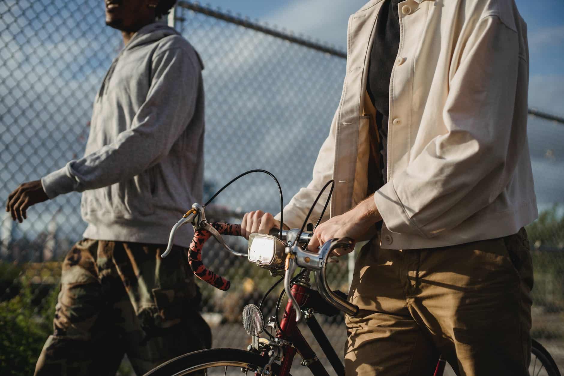 pexels photo 6141090 faceless multiethnic male friends strolling with bicycle in street